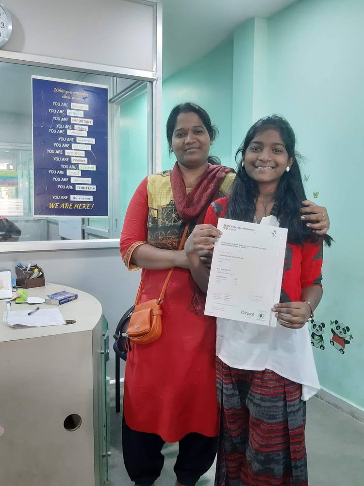 A Thrive student and her mother holding her Cambridge English A2 Key certificate.