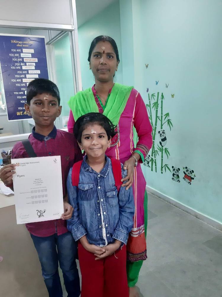 Siblings holding their Cambridge English Flyers certificate at Thrive Academy.